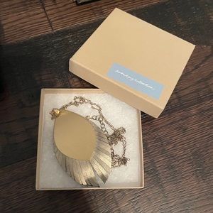 Noonday gold and black leather feather necklace.